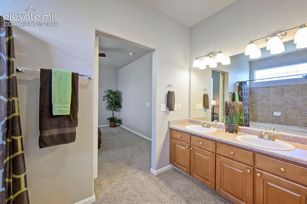 Image 23 of 45: Carpeted bedroom featuring a ceiling fan with integrated lighting, a panele