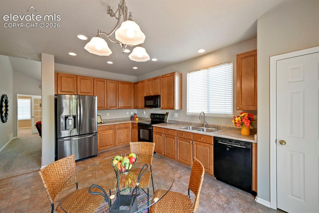 Image 8 of 45: Vaulted ceiling living area featuring neutral carpeting, a front entry door