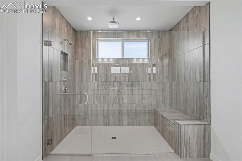 Image 15 of 37: Bathroom with double vanity, ensuite bathroom, a shower stall, light tile p