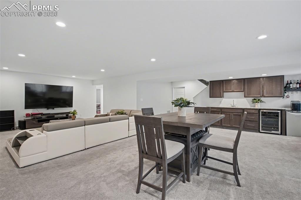 Image 32 of 37: Living room featuring light colored carpet, recessed lighting, and beverage