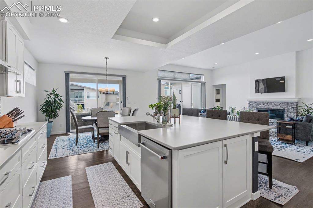 Image 9 of 37: Dining room with a raised ceiling, dark wood-type flooring, and suspended l