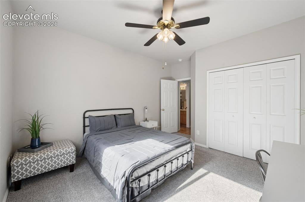 Image 12 of 37: Neutral wall tones, carpeting, a ceiling-mounted light fixture with a fan, 