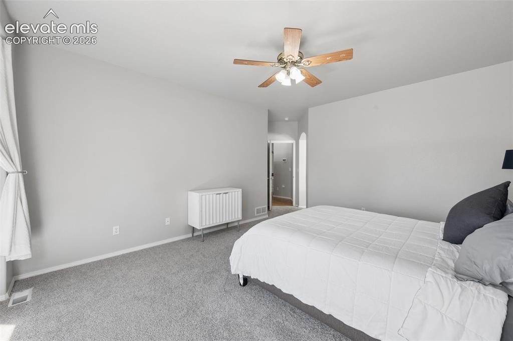 Image 14 of 37: Neutral wall palette featuring an arched entryway and a five-blade ceiling