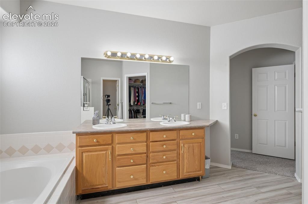 Image 17 of 37: Double vanity with light-tone wood cabinetry, solid surface countertop, dua