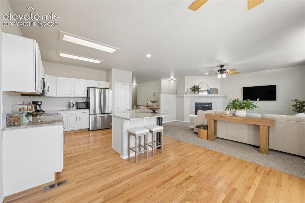 Image 23 of 37: Kitchen featuring white shaker-style cabinetry, stone-finish countertops, a