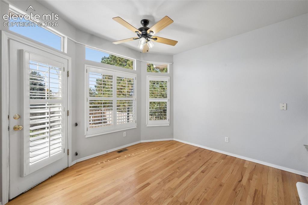 Image 24 of 37: Room featuring wood-finish flooring, plantation shutters, transom windows,