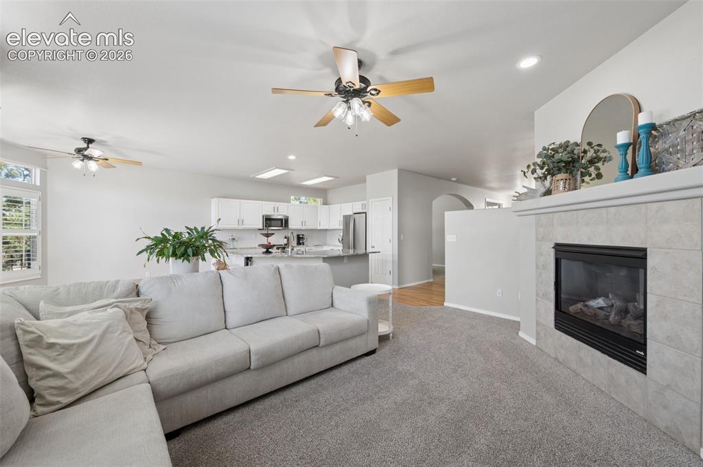 Image 26 of 37: Open-concept interior featuring a fireplace with stone-finish surround, cei