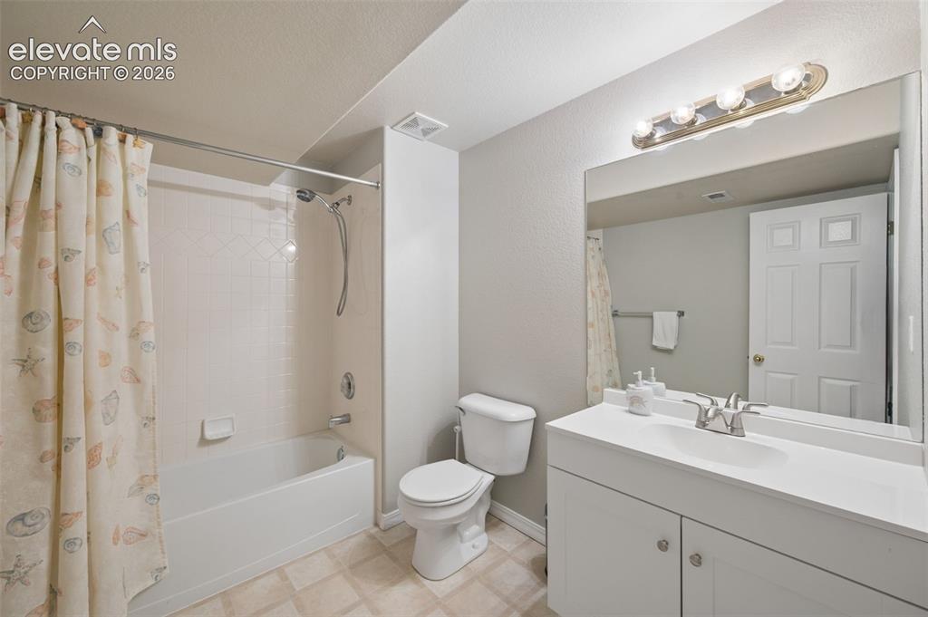 Image 33 of 37: Bathroom featuring a white vanity with an integrated basin, a large wall-mo