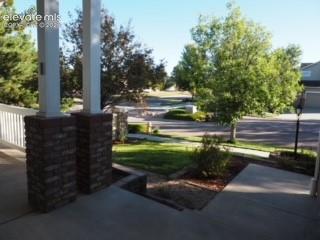 Image 5 of 37: Covered front porch featuring brick-base columns, concrete flooring, and a 