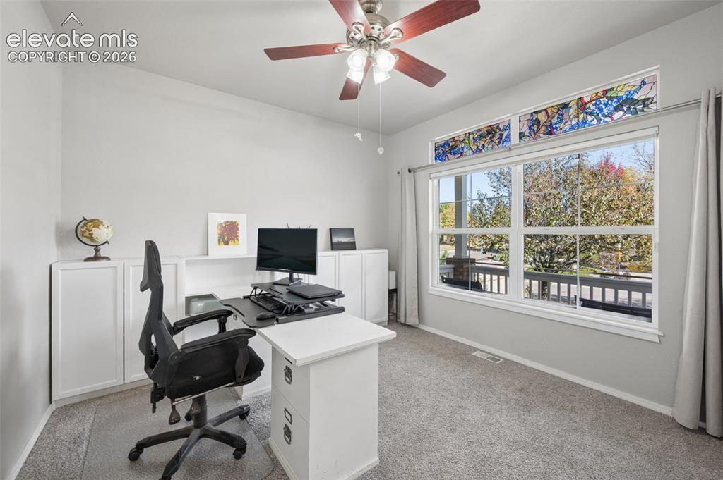 Image 6 of 37: Built-in white cabinetry, stained glass transom window, ceiling fan with in