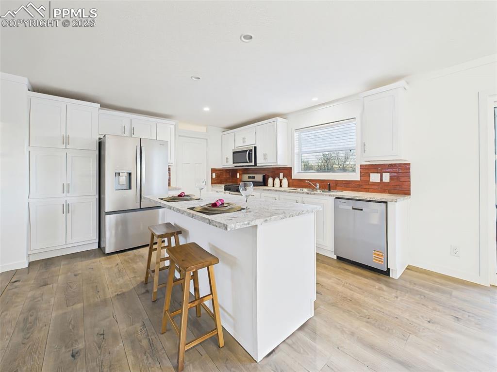 Image 14 of 50: Beautiful countertops, sleek white cabinetry, and a full suite of stainless
