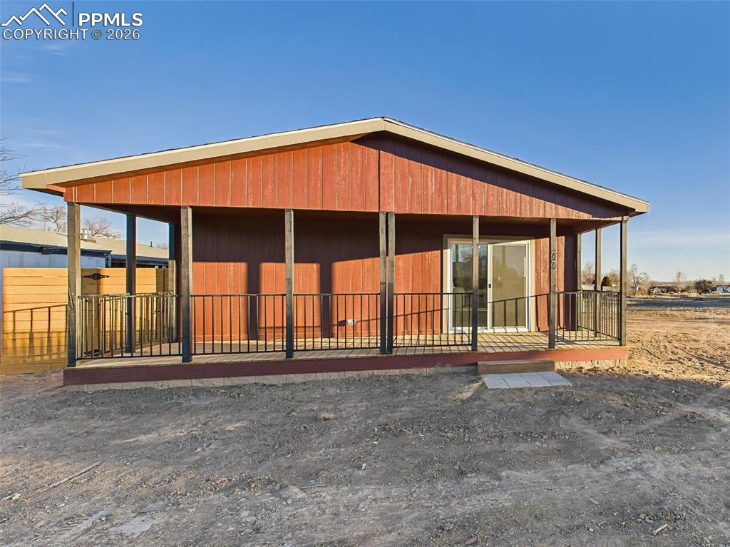 Image 2 of 50: A generous covered wood deck spans the front of the home, offering shade, p