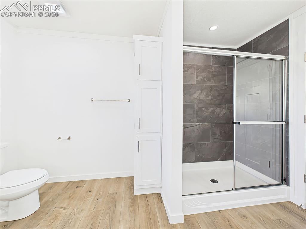 Image 30 of 50: A sleek glass-enclosed shower with modern tile surround complements the bui