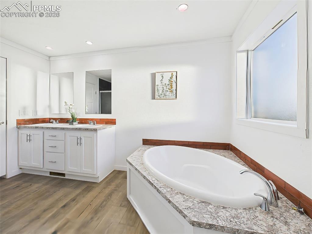 Image 31 of 50: The primary bath offers a spa-like retreat with a deep soaking tub, double