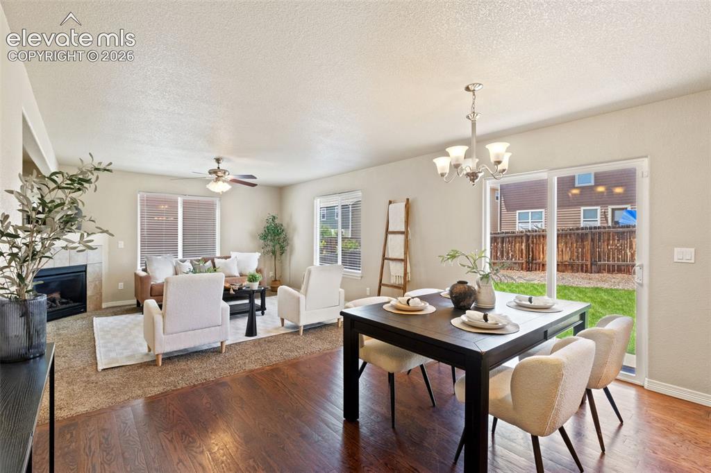Image 12 of 35: Open-concept living and dining areas featuring wood-finish flooring in the