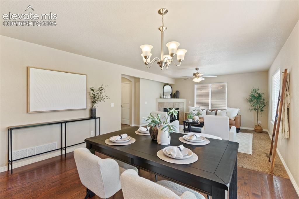 Image 13 of 35: Dining area with wood-finish flooring featuring a multi-light chandelier