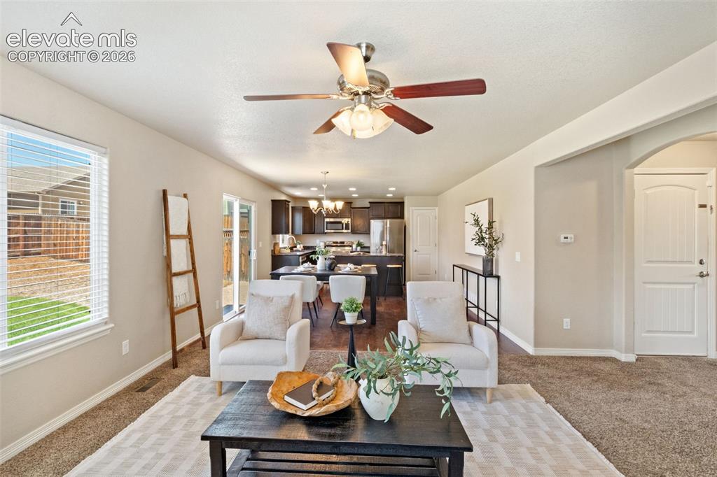 Image 15 of 35: Open-concept living area featuring a ceiling fan with integrated lighting,