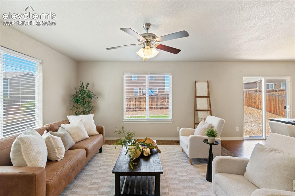 Image 17 of 35: Living area featuring neutral wall tones, multiple windows with blinds, a c