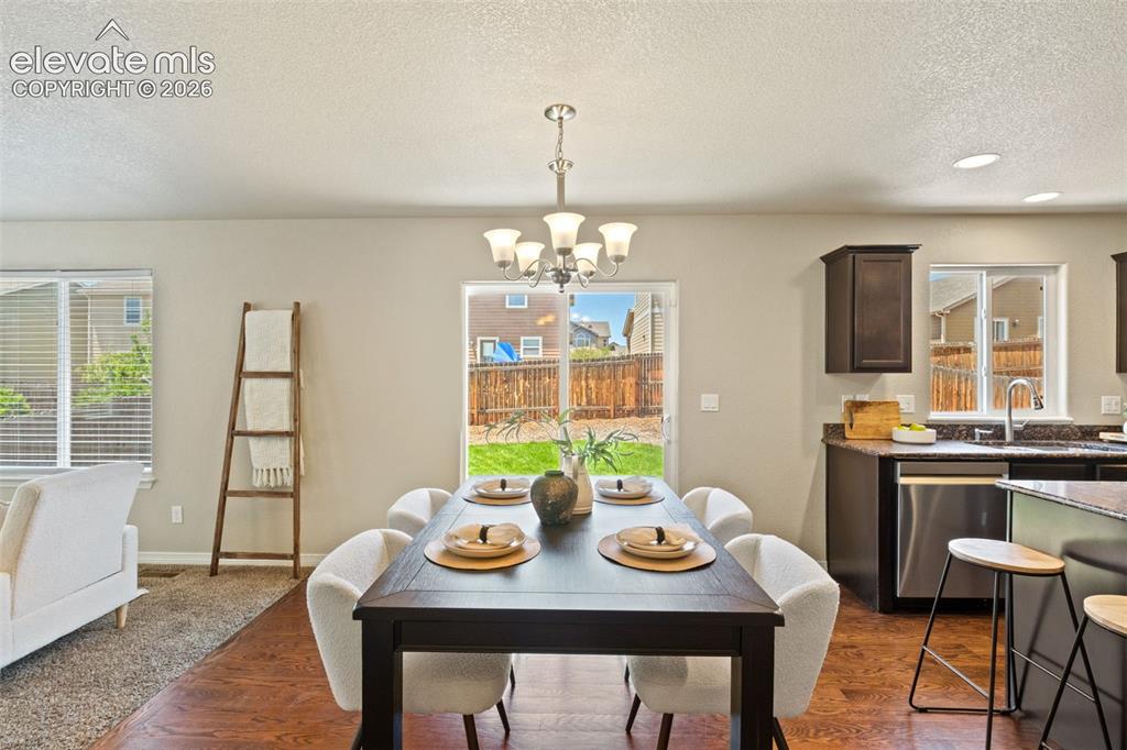 Image 9 of 35: Open-concept living space featuring wood-finish flooring, a contemporary di