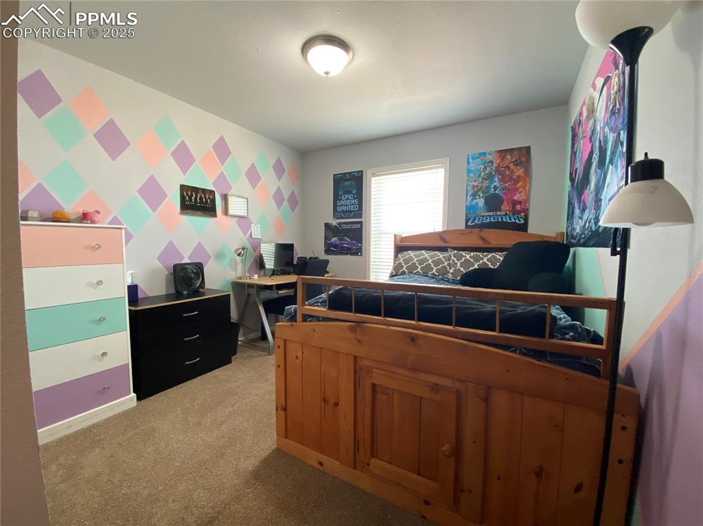 Image 17 of 48: Bright and airy second main-floor bedroom featuring generous space and natu