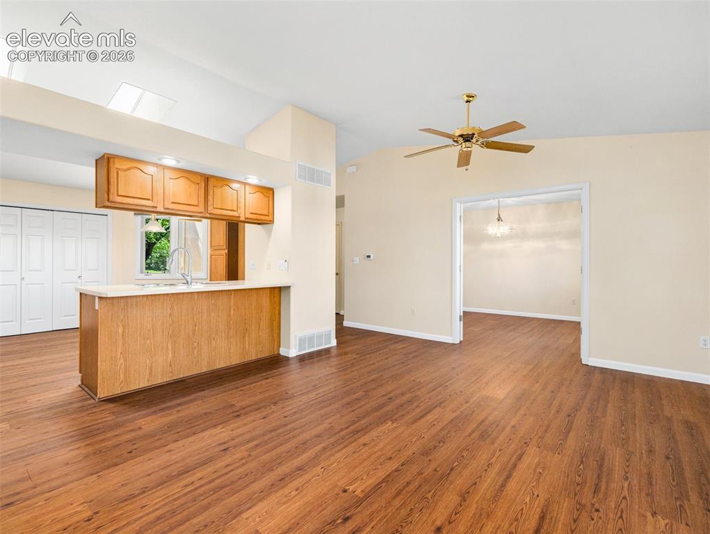 Image 11 of 24: Open-concept living area featuring wood-finish flooring throughout, a vault