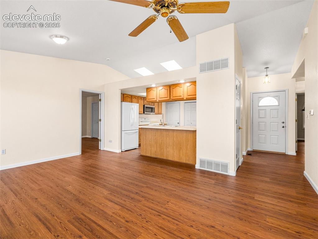 Image 12 of 24: Open-concept living area featuring wood-finish flooring, a ceiling fan, and