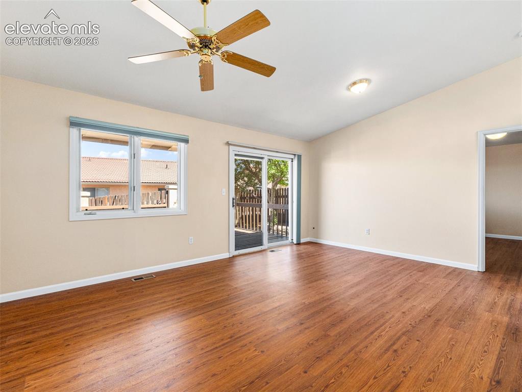 Image 13 of 24: Spacious room featuring wood-finish flooring, vaulted ceilings, and a ceili