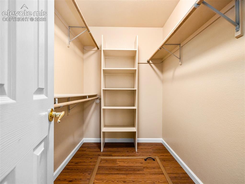 Image 18 of 24: Walk-in closet featuring wood-finish flooring, built-in shelving, and multi