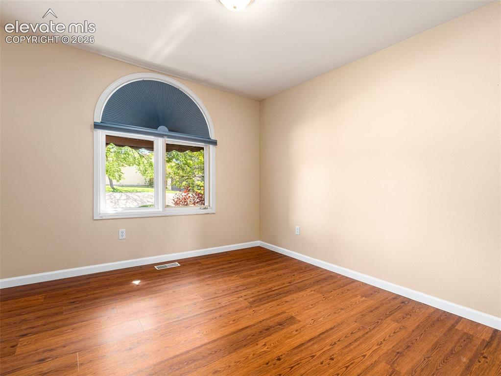 Image 2 of 24: Room featuring a large arched window with transom, wood-finish flooring, an