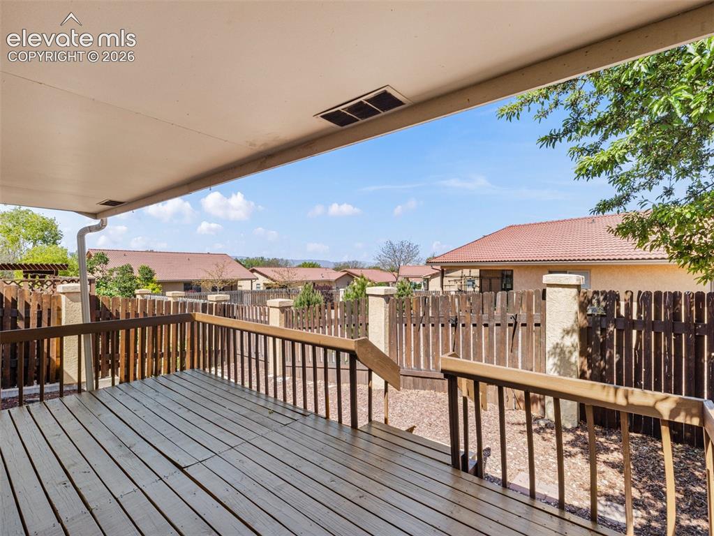 Image 20 of 24: Expansive covered deck featuring wood decking and a perimeter railing