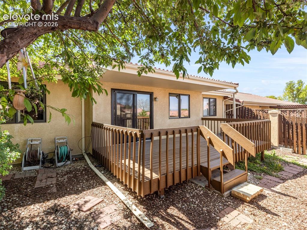 Image 21 of 24: Expansive wooden deck with railing and dual stair access
