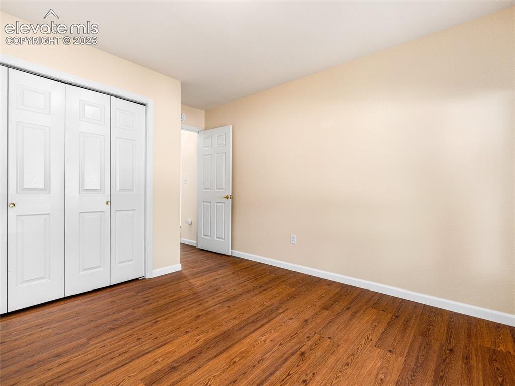 Image 3 of 24: Room featuring wood-finish flooring, light-toned walls, white baseboards, a