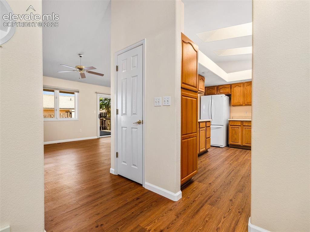 Image 4 of 24: Wood-finish flooring throughout, featuring a kitchen with wood cabinetry an