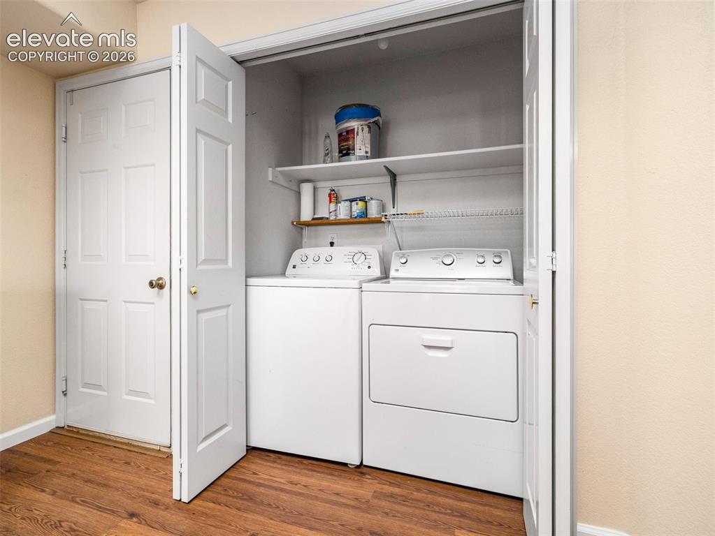 Image 7 of 24: Dedicated laundry closet featuring a washer and dryer, bifold doors, and up