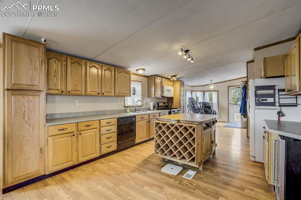 Image 14 of 43: Kitchen featuring wine cooler, light wood-style floors, white appliances, a