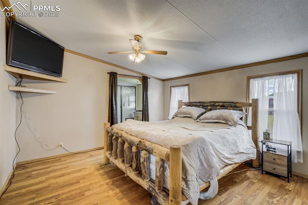 Image 18 of 43: Bedroom with ornamental molding, light wood finished floors, ceiling fan, a