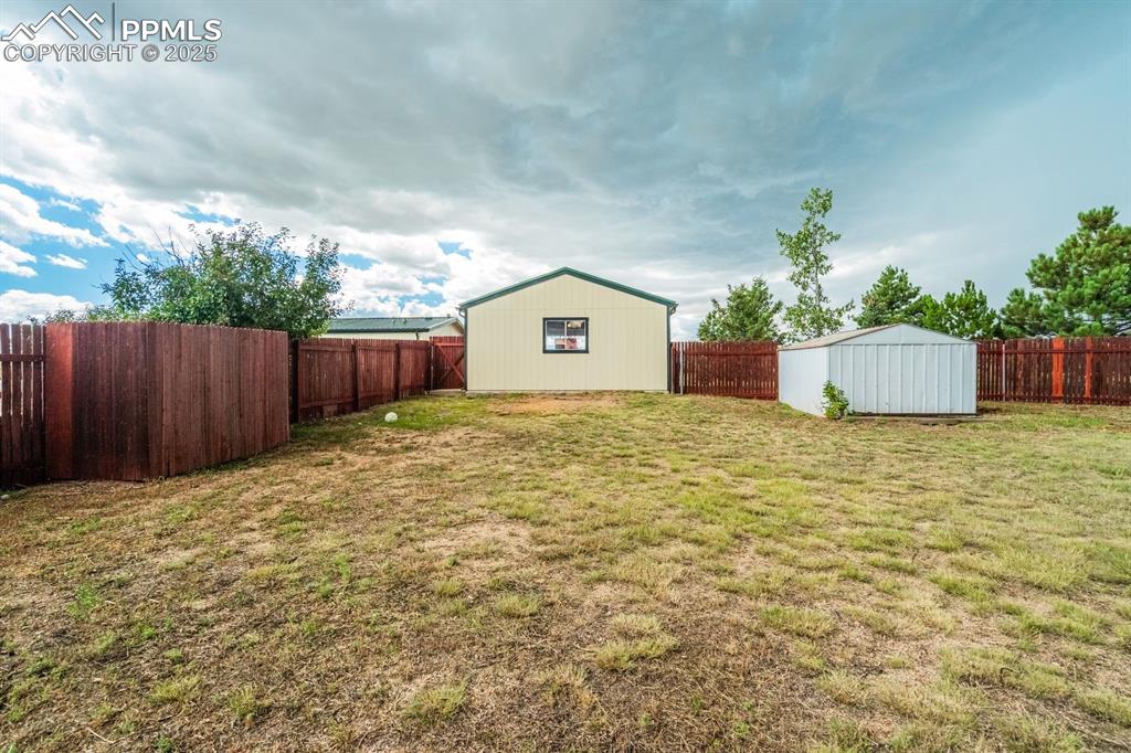 Image 37 of 43: Fenced backyard featuring a shed