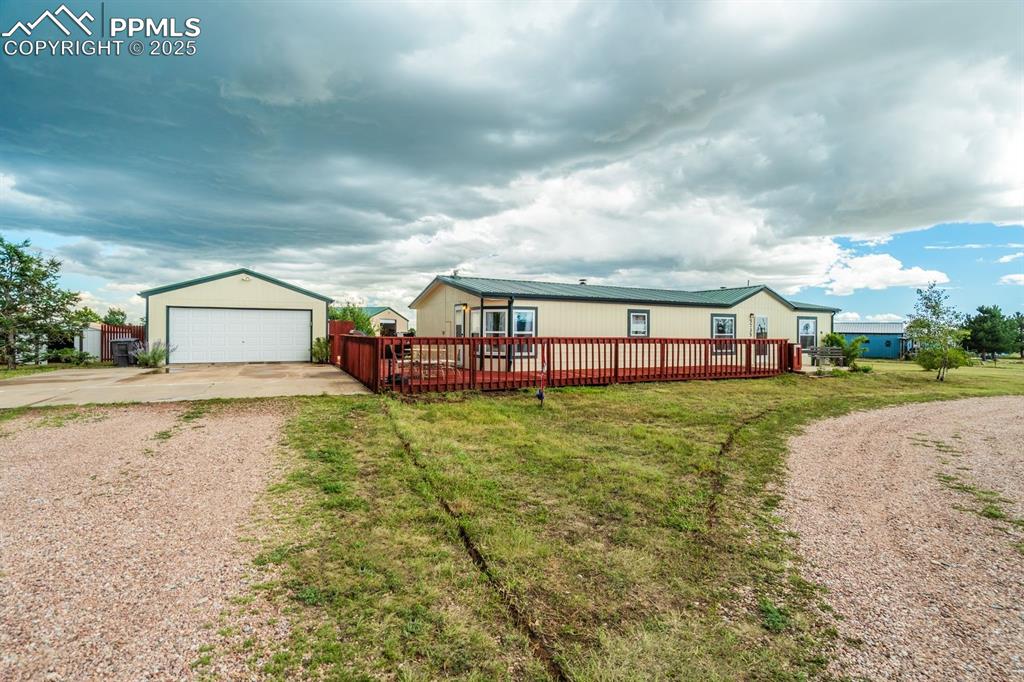 Image 6 of 43: View of front of home featuring an outdoor structure, a detached garage, an