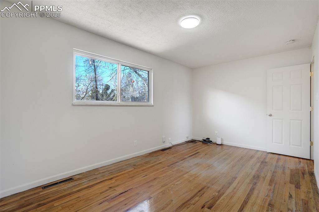 Image 13 of 34: Main level bedroom with HW floors