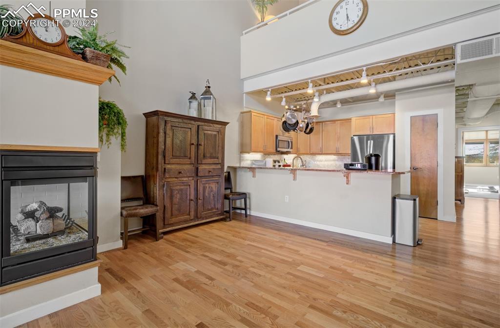 Image 13 of 42: Spacious dining room area has hardwood flooring enjoys the gas fireplace