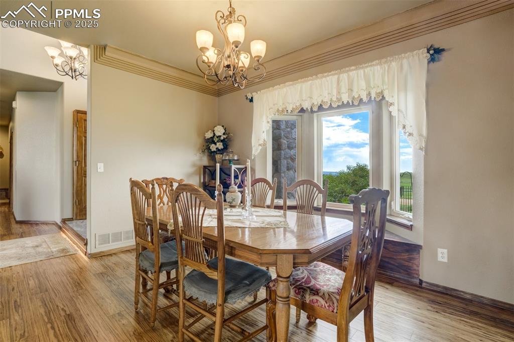 Image 15 of 50: Formal dining with bay window, city views, and eucalyptus flooring