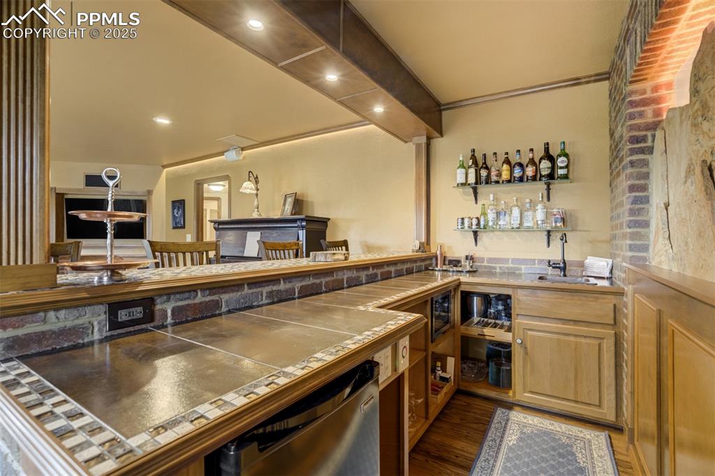 Image 34 of 50: Custom wet-bar includes beverage fridge and microwave