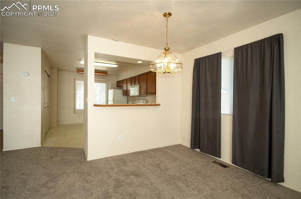 Image 3 of 25: Dining area with countertop bar to the kitchen