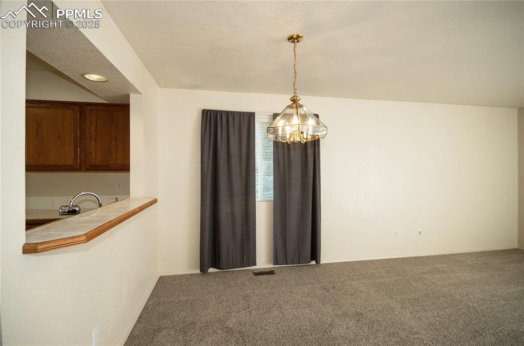 Image 7 of 25: Dining area with countertop bar to the kitchen