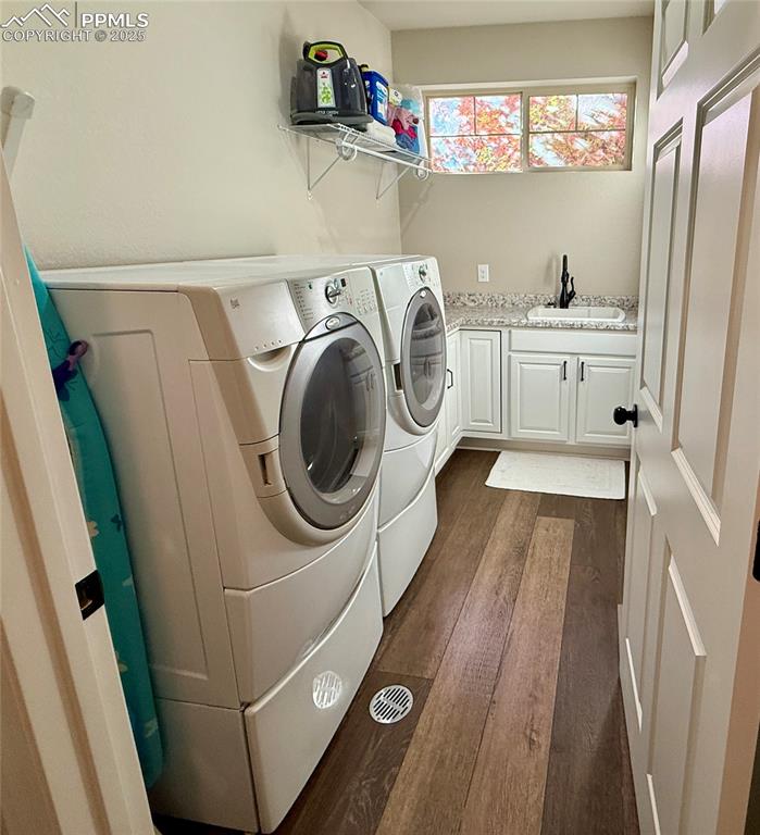 Image 18 of 28: Laundry room featuring dark wood-type flooring, with sink and cabinets on m