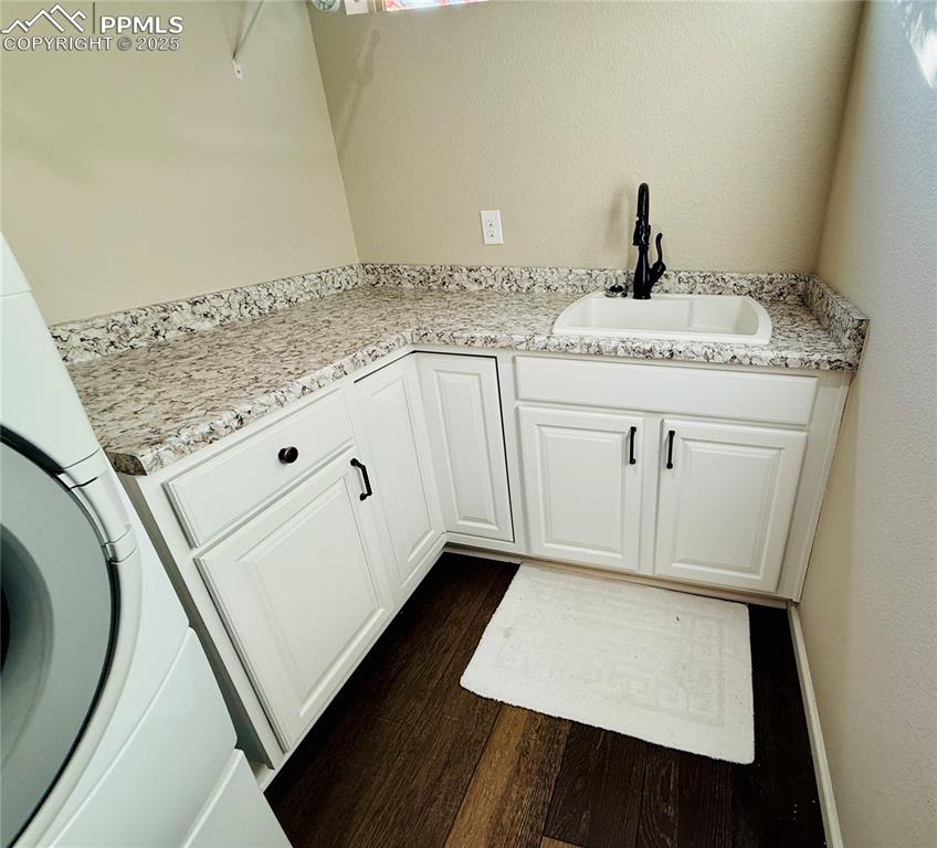 Image 19 of 28: Laundry area with dark wood-style floors