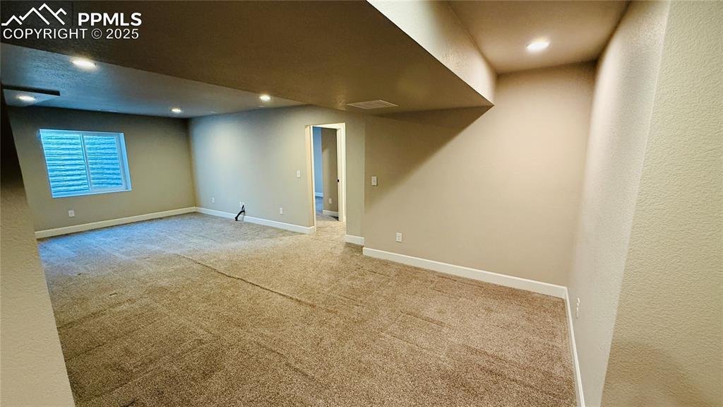 Image 21 of 28: Basement with carpet flooring, recessed lighting, and a textured wall
