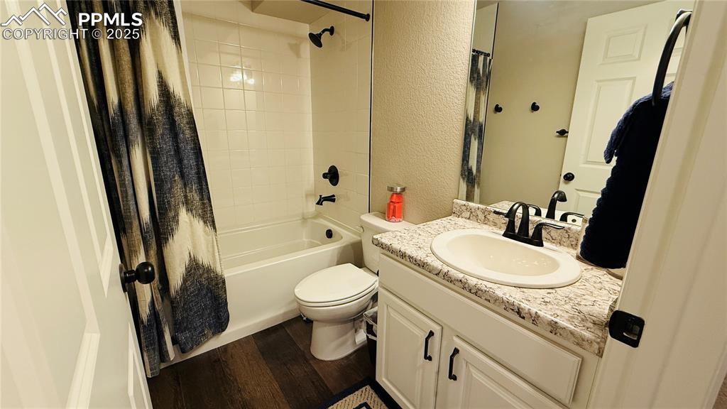 Image 22 of 28: Full basement bathroom with vanity, wood finished floors, shower / bath com