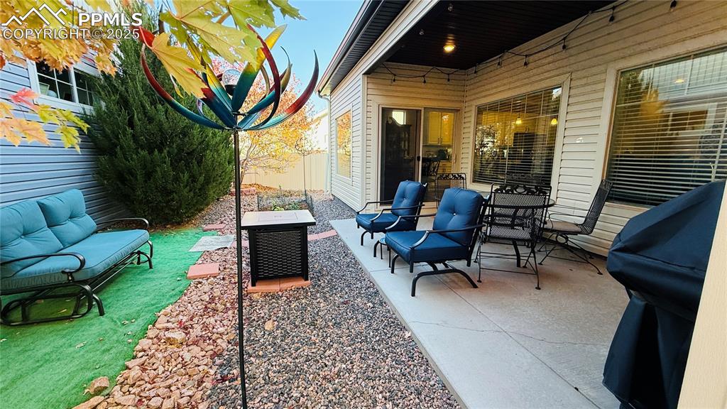 Image 26 of 28: View of covered patio featuring area for grilling and outdoor lounge area