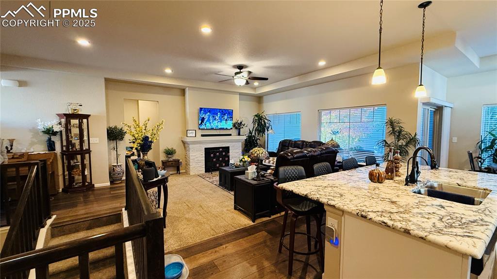 Image 9 of 28: Kitchen with dark wood-type flooring, decorative light fixtures, ceiling fa